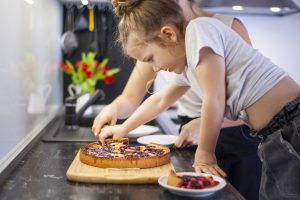 adorable-young-girl-sharing-cake-with-mother